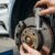 Ein Mechaniker prüft sorgfältig die Bremsen eines gebrauchten E-Autos in einer Werkstatt.