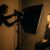 Eine Fotografin bei der professionellen Lichtsetzung für ein Porträtfoto im Studio.