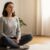 Eine Person meditiert entspannt in einem sonnigen Raum als Einstieg in die Meditation für Anfänger.