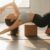 Eine Person nutzt einen Yogablock zur Unterstützung in der Halbmond-Pose, um die richtige Ausrichtung zu demonstrieren.