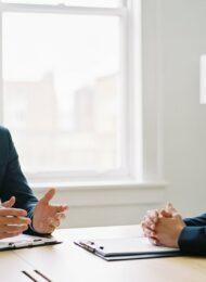Ein Mitarbeiter präsentiert überzeugende Argumente in seiner Gehaltsverhandlung mit der Chefin.