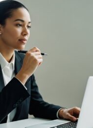 Eine Person formuliert am Schreibtisch konzentriert ihre Gehaltsvorstellung für die Bewerbung.